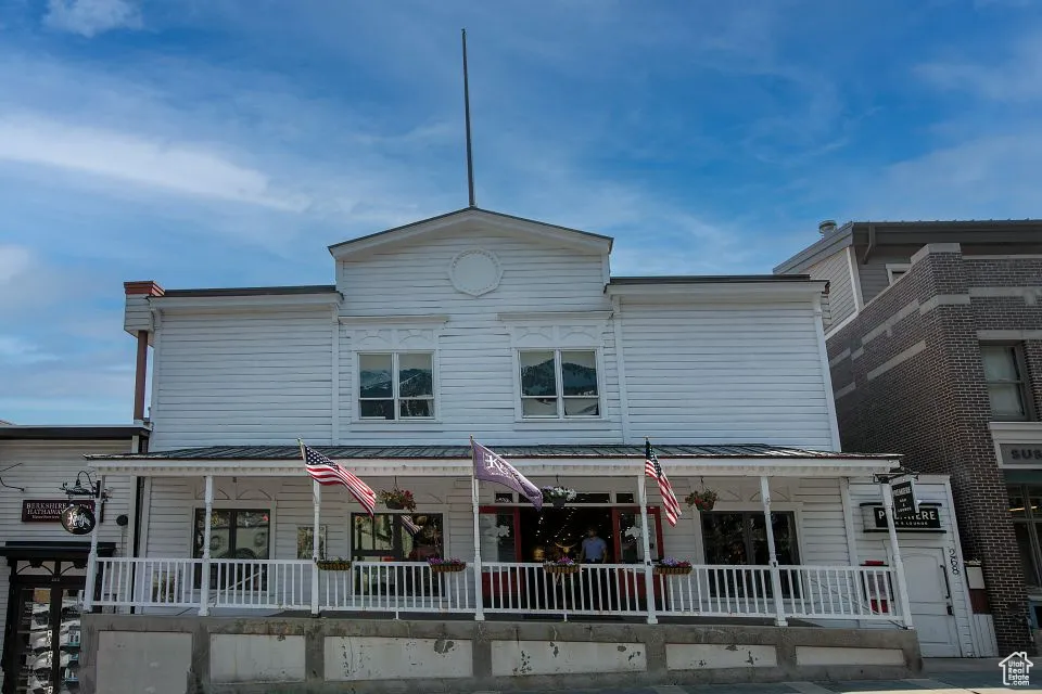 View of front facade with a standing seam roof, a porch, and metal roof