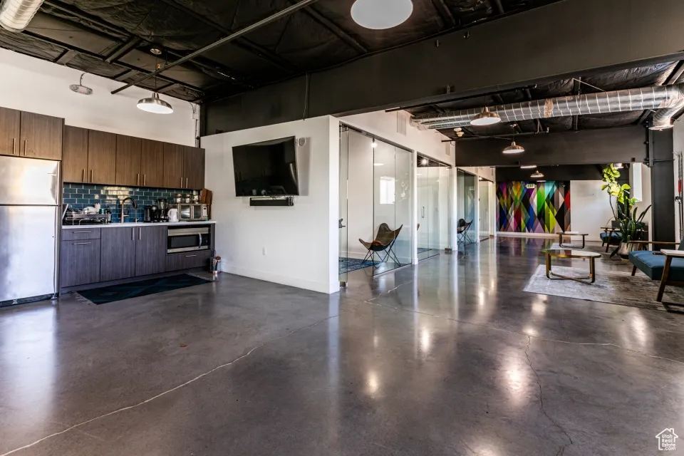 Garage featuring baseboards and stainless steel fridge