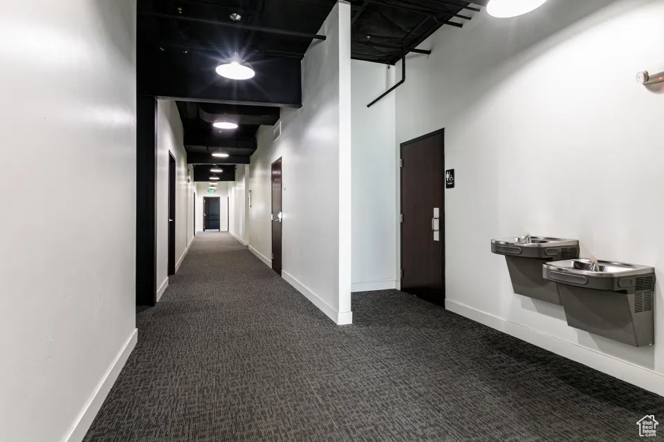 Hall with dark carpet and baseboards
