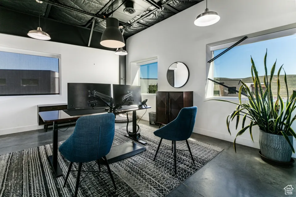 Office featuring finished concrete floors, baseboards, and visible vents