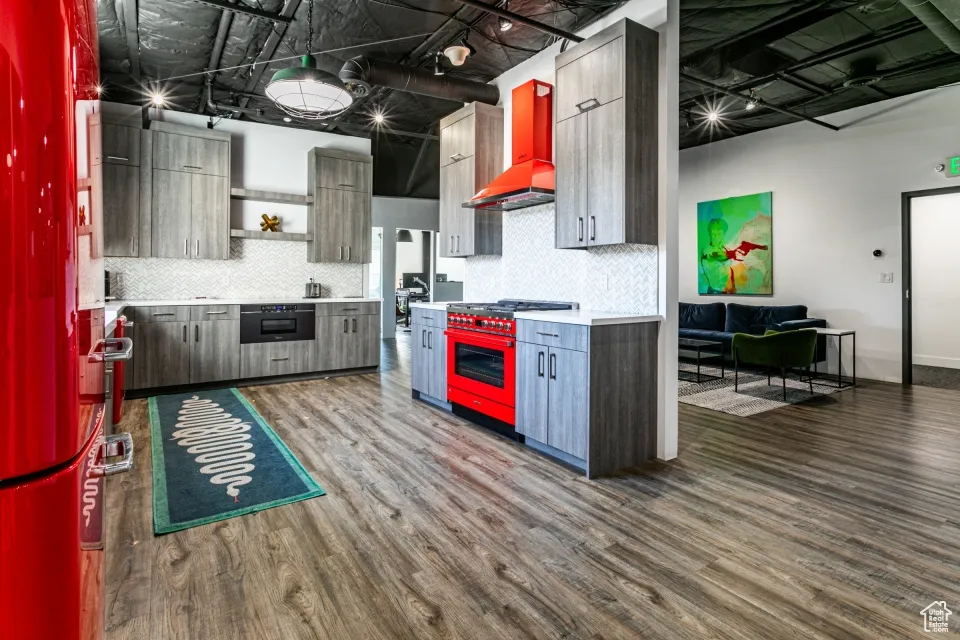 Kitchen with modern cabinets, wall chimney range hood, open shelves, dark wood-style flooring, and stainless steel range
