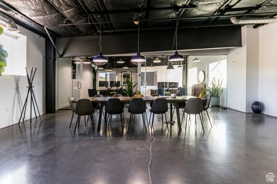 Dining space featuring concrete floors, baseboards, and a wealth of natural light