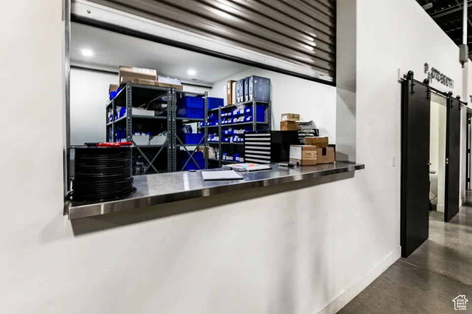 Bar featuring concrete floors, baseboards, and a barn door