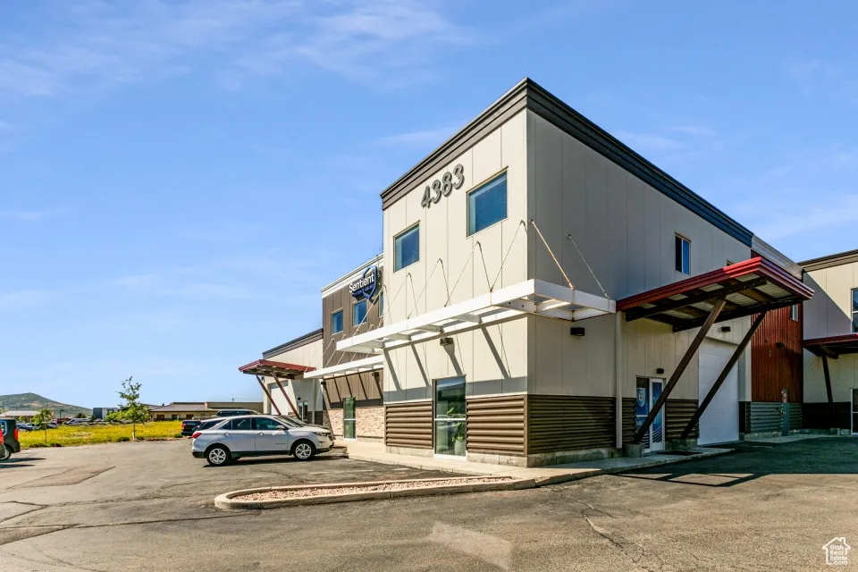 View of building exterior with uncovered parking