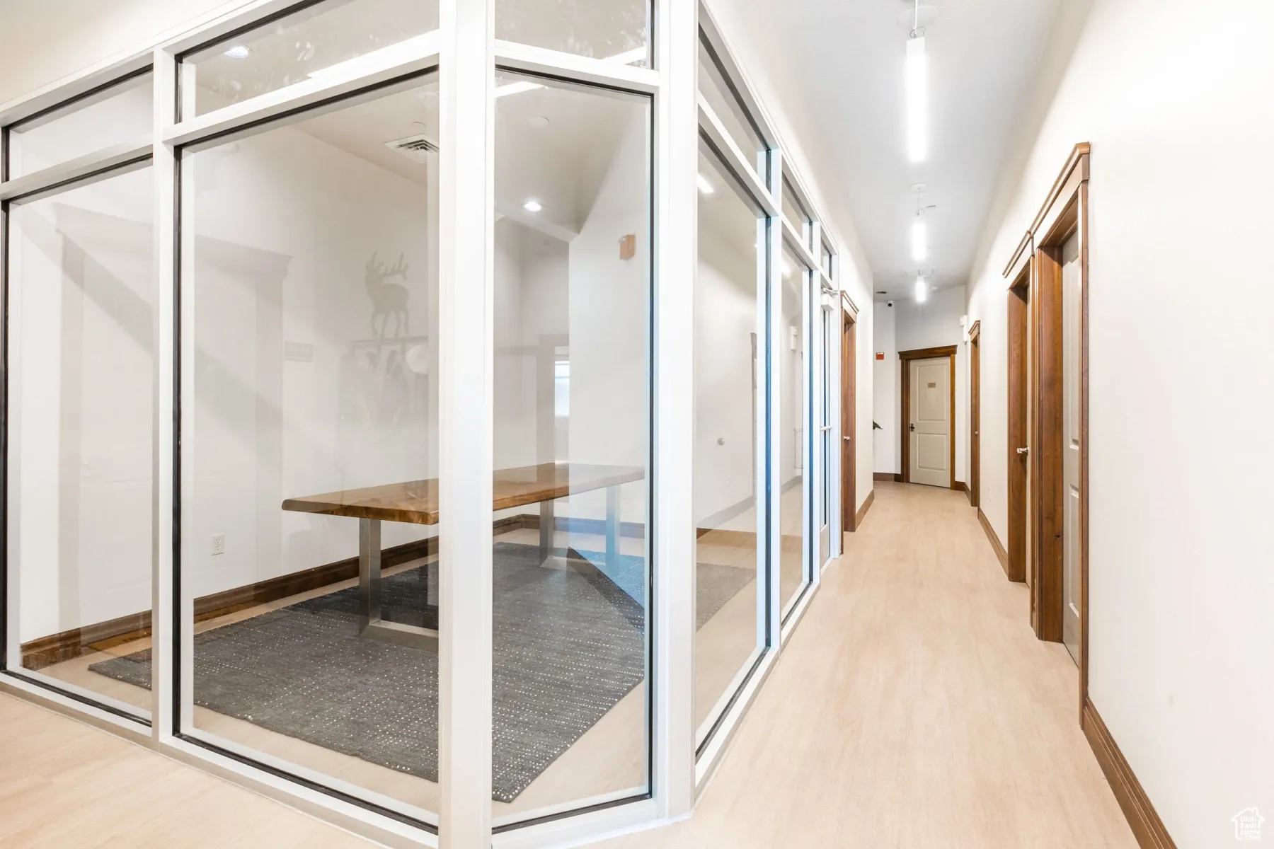 Hall featuring light wood-type flooring, baseboards, and visible vents