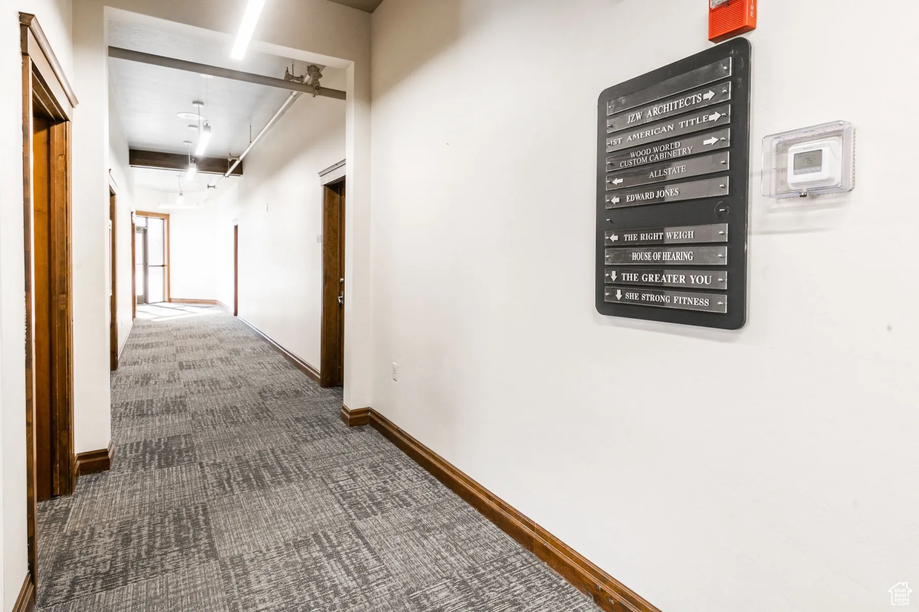 Hall featuring baseboards and carpet