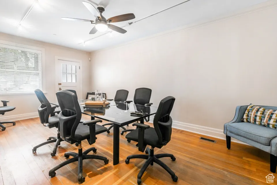 Office area featuring crown molding, visible vents, baseboards, and light wood finished floors