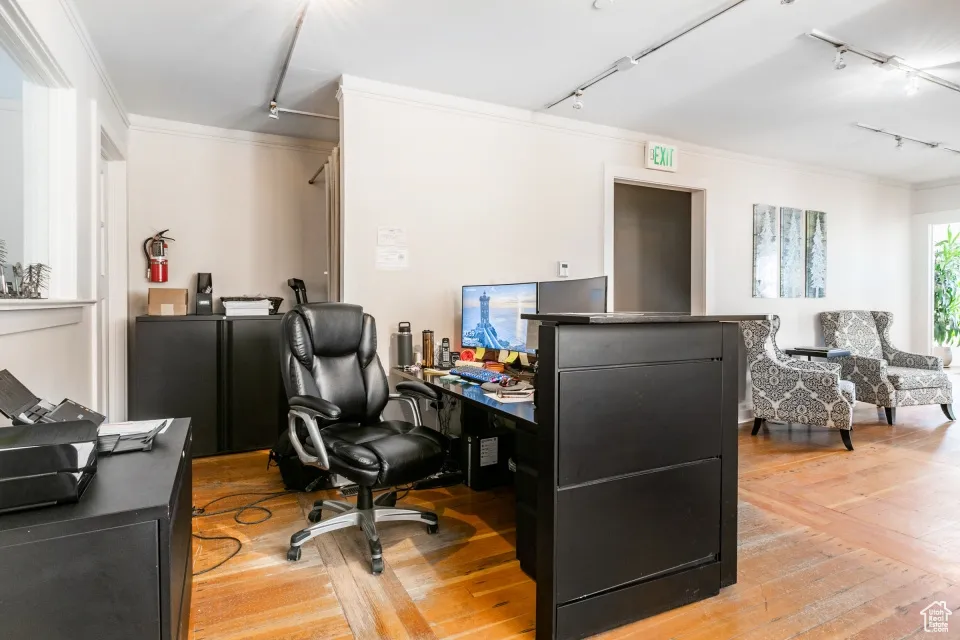 Office area featuring ornamental molding, track lighting, and light wood-style floors