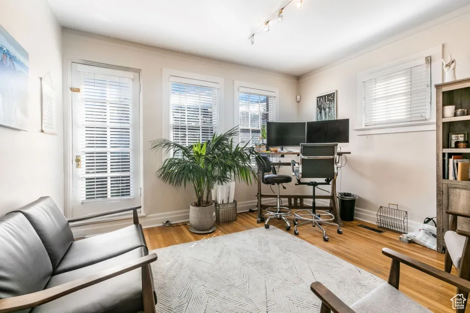 Home office featuring wood finished floors, baseboards, and rail lighting