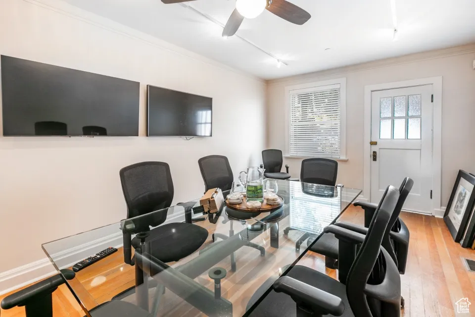 Home office featuring ceiling fan, visible vents, crown molding, and wood finished floors