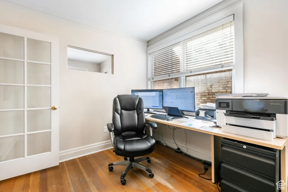 Office area with baseboards, hardwood / wood-style floors, and crown molding