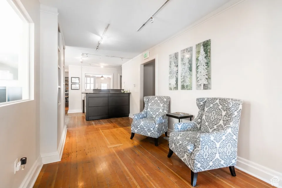 Living area featuring baseboards, hardwood / wood-style floors, and track lighting