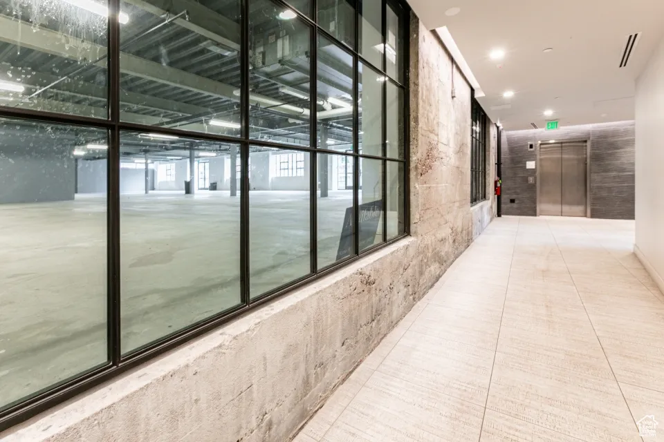 Hall featuring tile patterned floors, recessed lighting, visible vents, and elevator