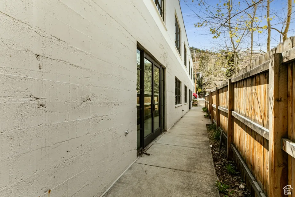 View of side of home featuring concrete block siding and fence