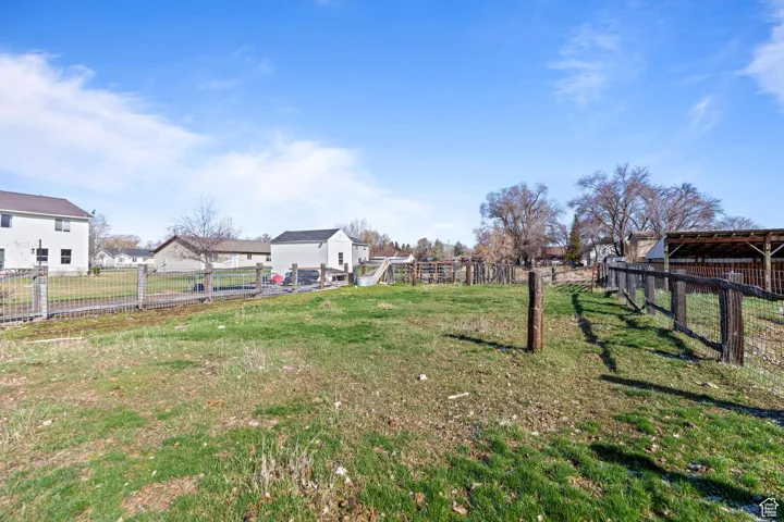 View of yard featuring a residential view, an outdoor structure, and fence