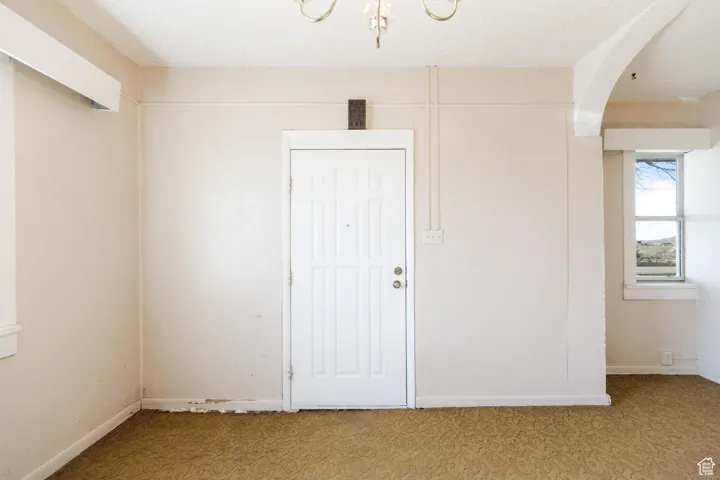 Empty room with light carpet and arched walkways