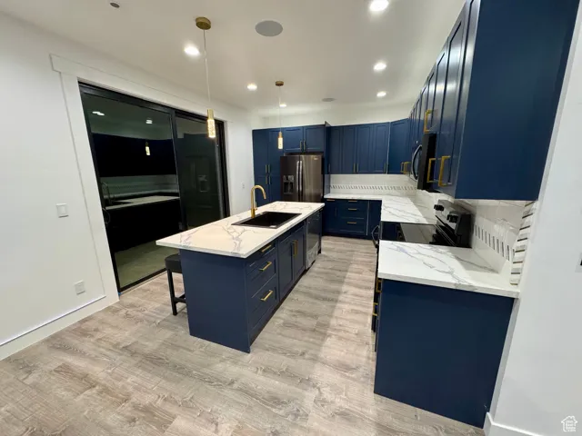 Kitchen featuring a sink, light wood-type flooring, black appliances, and blue cabinets