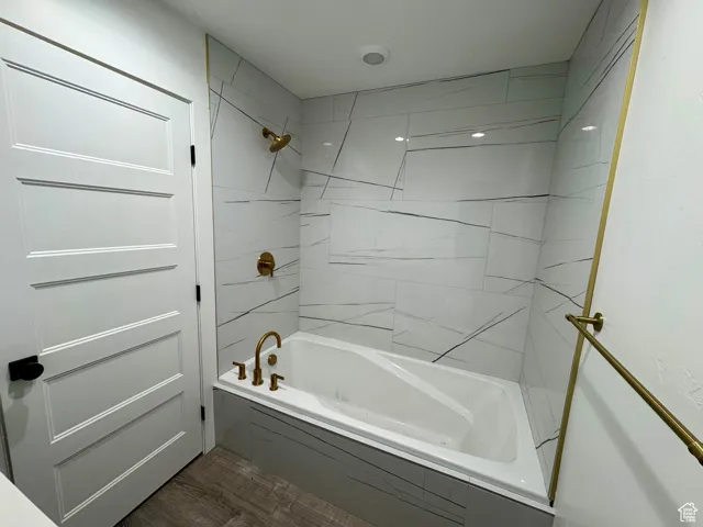 Bathroom featuring  shower combination and wood finished floors