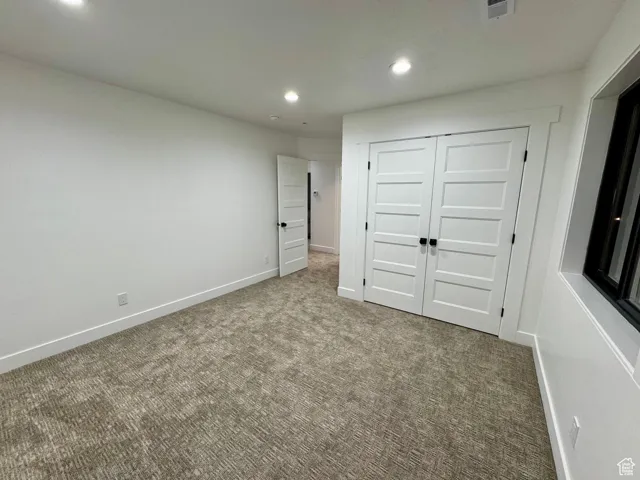 Unfurnished bedroom featuring recessed lighting, carpet, and baseboards
