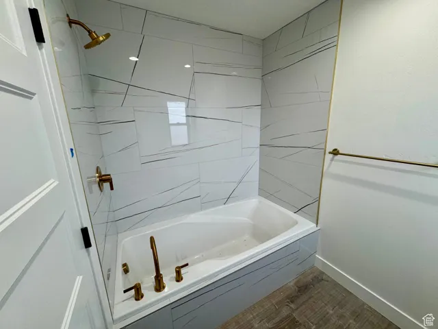 Full bathroom with  shower combination, baseboards, and wood finished floors