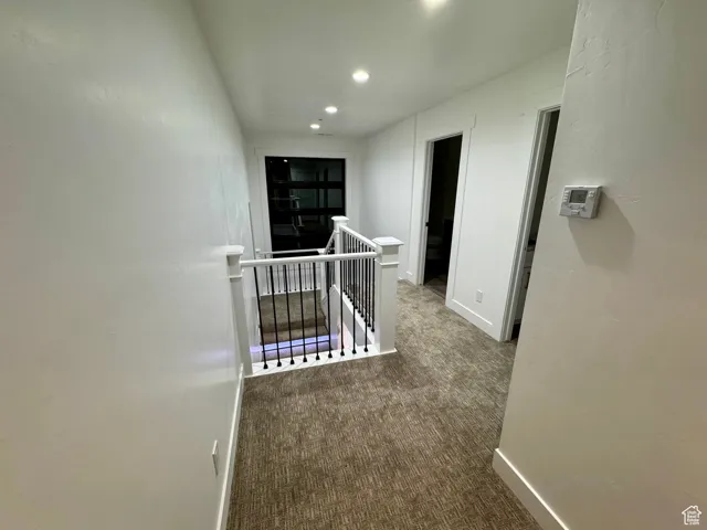 Corridor featuring recessed lighting, an upstairs landing, baseboards, and carpet floors