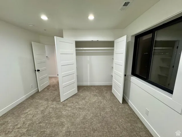 Unfurnished bedroom featuring recessed lighting, carpet flooring, visible vents, and baseboards