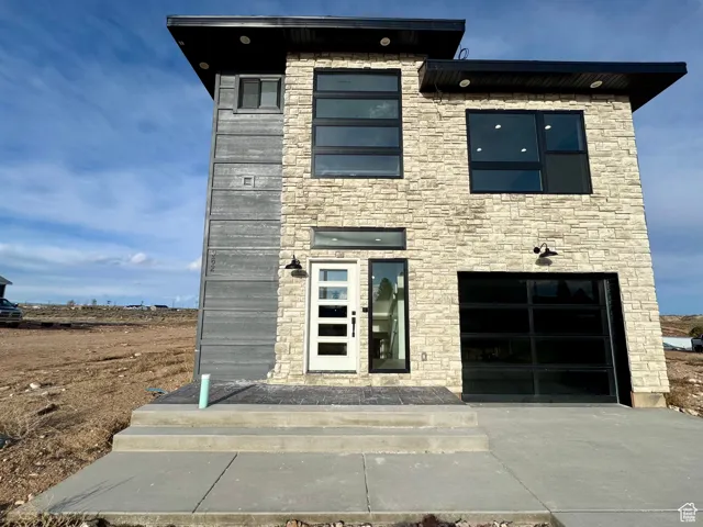 Contemporary house featuring driveway and stone siding