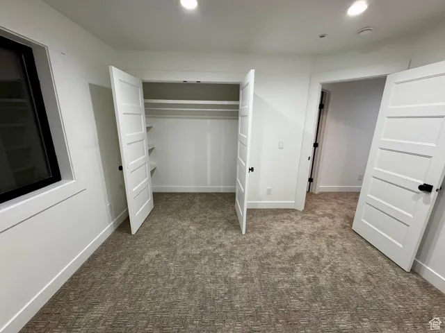 Unfurnished bedroom featuring a closet, baseboards, recessed lighting, and carpet