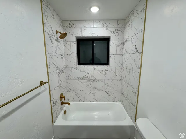 Bathroom with toilet and tub / shower combination
