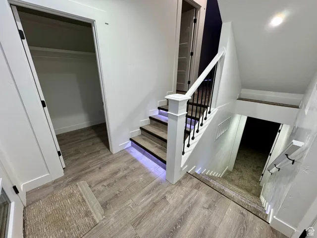 Stairway with visible vents, baseboards, and wood finished floors