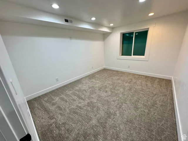Unfurnished room featuring baseboards, carpet, visible vents, and recessed lighting