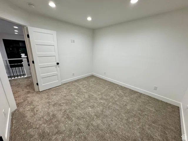 Carpeted empty room featuring baseboards and recessed lighting