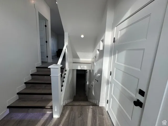 Staircase featuring wood finished floors and baseboards
