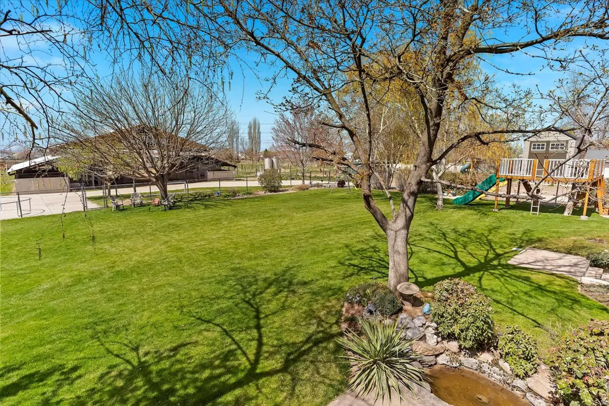 Expansive green lawn with mature trees and a built-in water feature