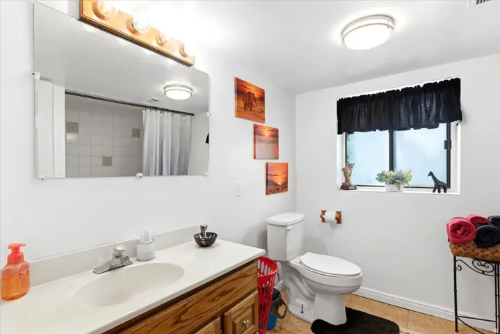 Bathroom with a single vanity featuring a wood-finish cabinet and a white countertop