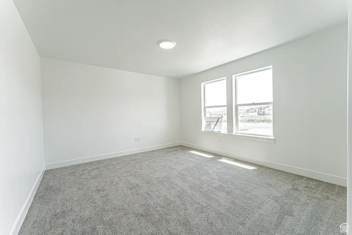 Carpeted empty room with baseboards and a textured ceiling