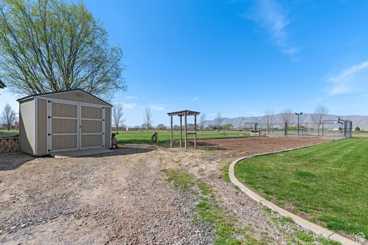 View of yard featuring a storage shed, an outbuilding, and a mountain view