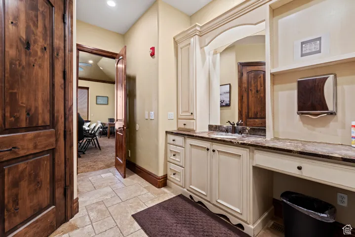 Bathroom featuring recessed lighting, vanity, stone tile floors, and baseboards