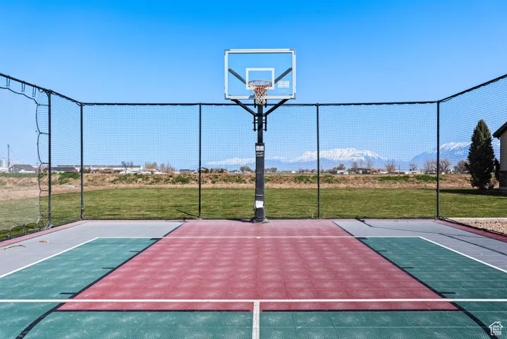 View of sport court featuring a yard and basketball court