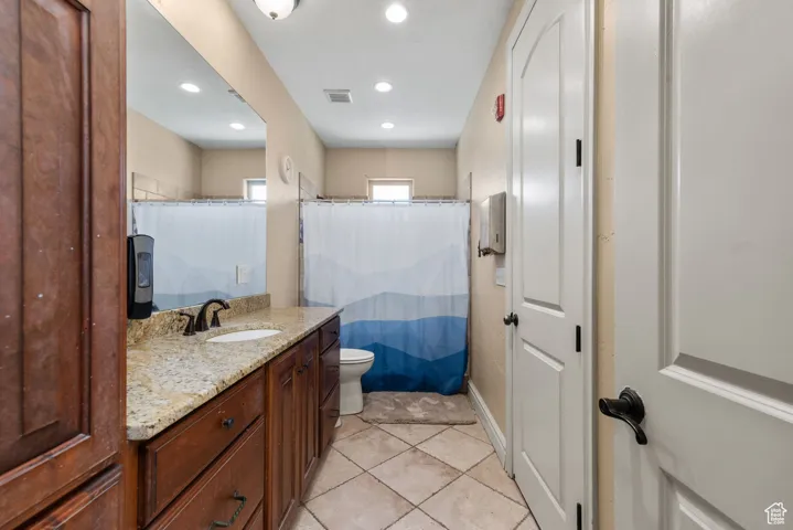 Bathroom with tile patterned flooring, recessed lighting, vanity, and visible vents