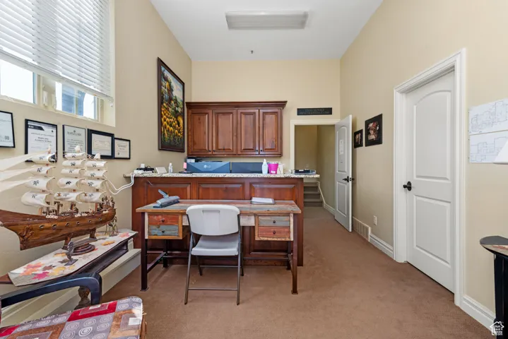 Office area with baseboards and light colored carpet