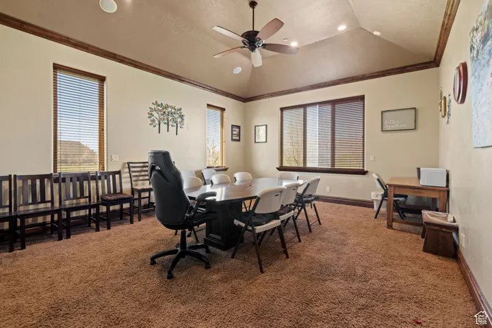 Dining space with a wealth of natural light, carpet, vaulted ceiling, and ceiling fan