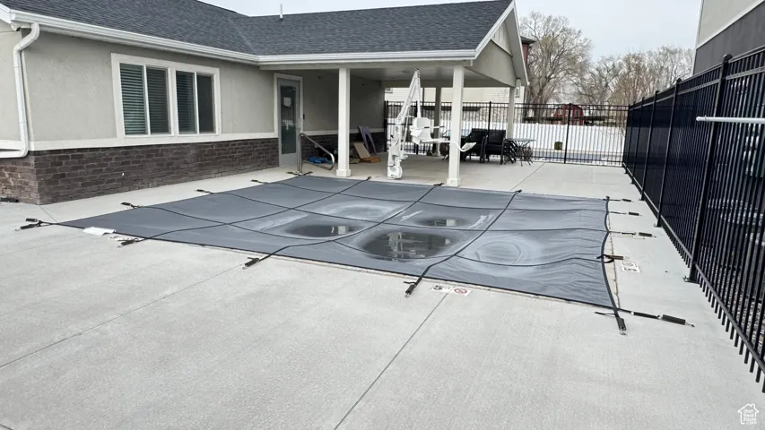 View of swimming pool featuring a fenced in pool, a patio, and fence