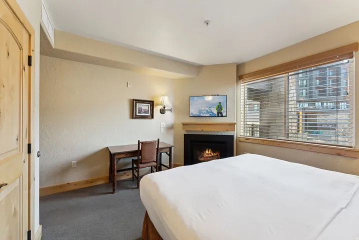 Built-in fireplace with wood-finish mantel and mounted television