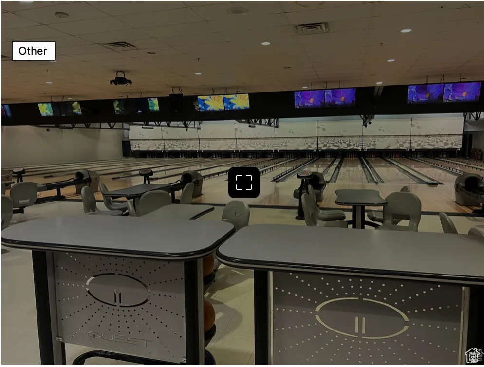 Interior space featuring a paneled ceiling, visible vents, and bowling