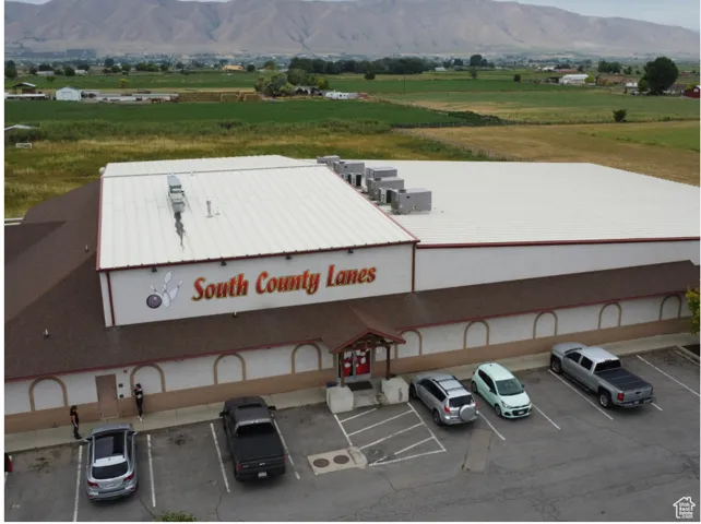 View of building exterior with a rural view, central air condition unit, uncovered parking, and a mountain view