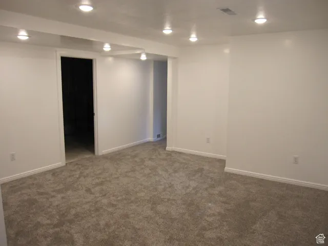 Finished basement featuring visible vents, baseboards, recessed lighting, and carpet