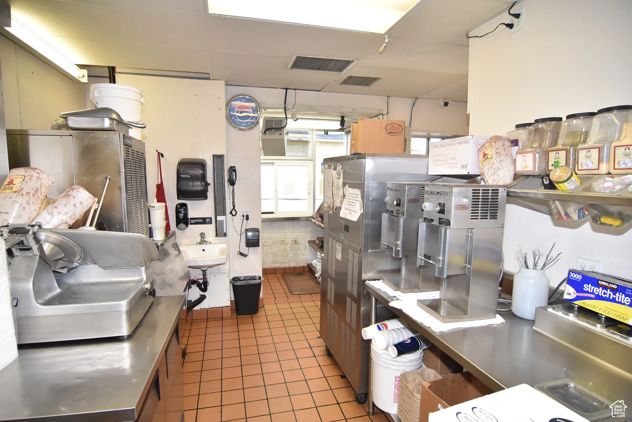 Kitchen with stainless steel countertops, tile floors, ice cream machines and other items