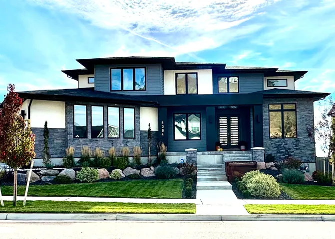 View of front of property with a front lawn and stone siding