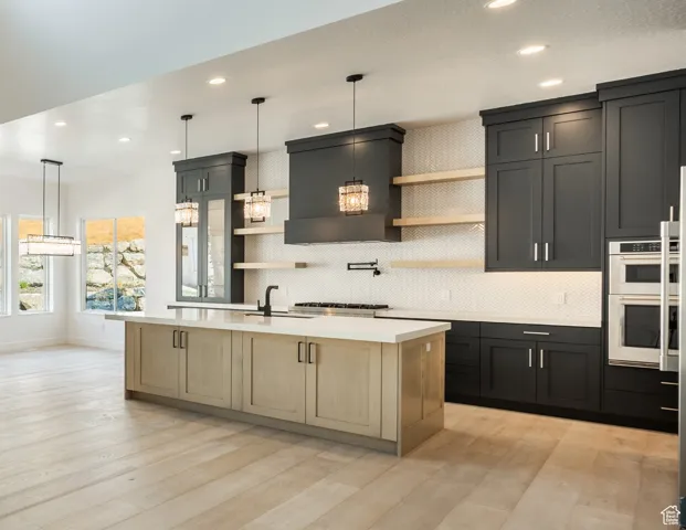Kitchen with open shelves, a sink, white double oven, light countertoKitchen with tasteful backsplash, open shelves, a high ceiling, light countertops, double oven, and recessed lighting